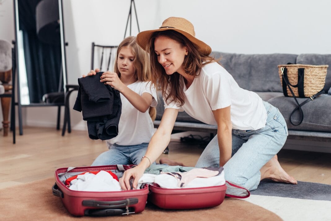 Matka i córka pakują wspólnie niewielką walizkę na wyjazd - niupak.eu