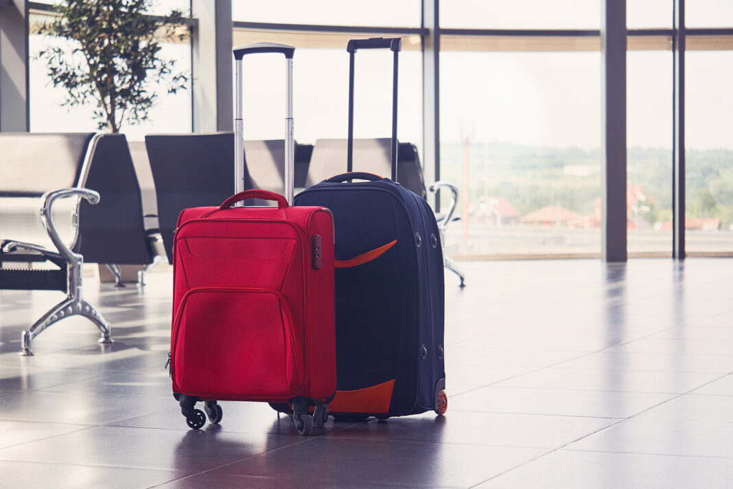 two suitcases are on the floor in airport waiting room walizki podróżne na lotnisku
