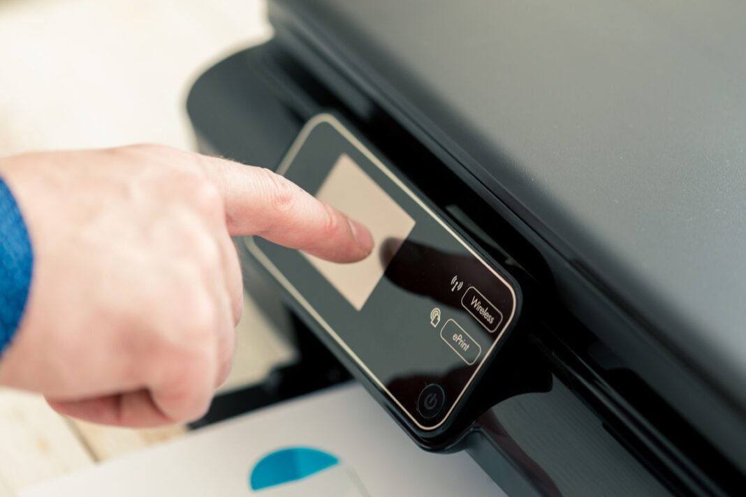Man's hand making copies. Working with printer