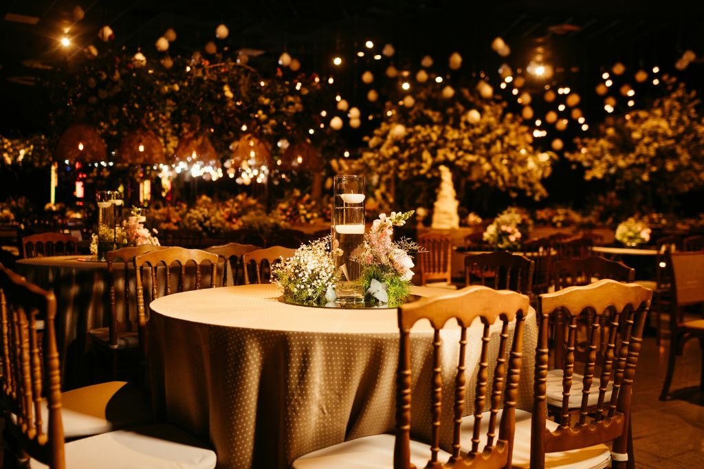  Elegancka sala weselna ozdobiona kwiatami i świecami, gotowa na przyjęcie weselne w stylu glamour – idealna przestrzeń na ślub konkordatowy lub tradycyjne wesele w Łodzi. 