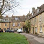 Lacock Abbey: Skarbiec Historii i Filmu Malownicza ulica w tradycyjnej angielskiej wiosce z historycznymi kamiennymi domami w Cotswold i spokojną atmosferą.