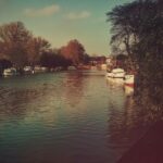 Spokojny widok na rzekę z łodziami i drzewami w Beccles w Wielkiej Brytanii.