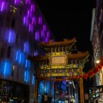 Oświetlona brama Chinatown w Londynie, ukazująca kolorowe życie nocne miasta.