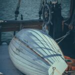 Zbliżenie na zabytkową łódź z linami i kołem w porcie Bristol.