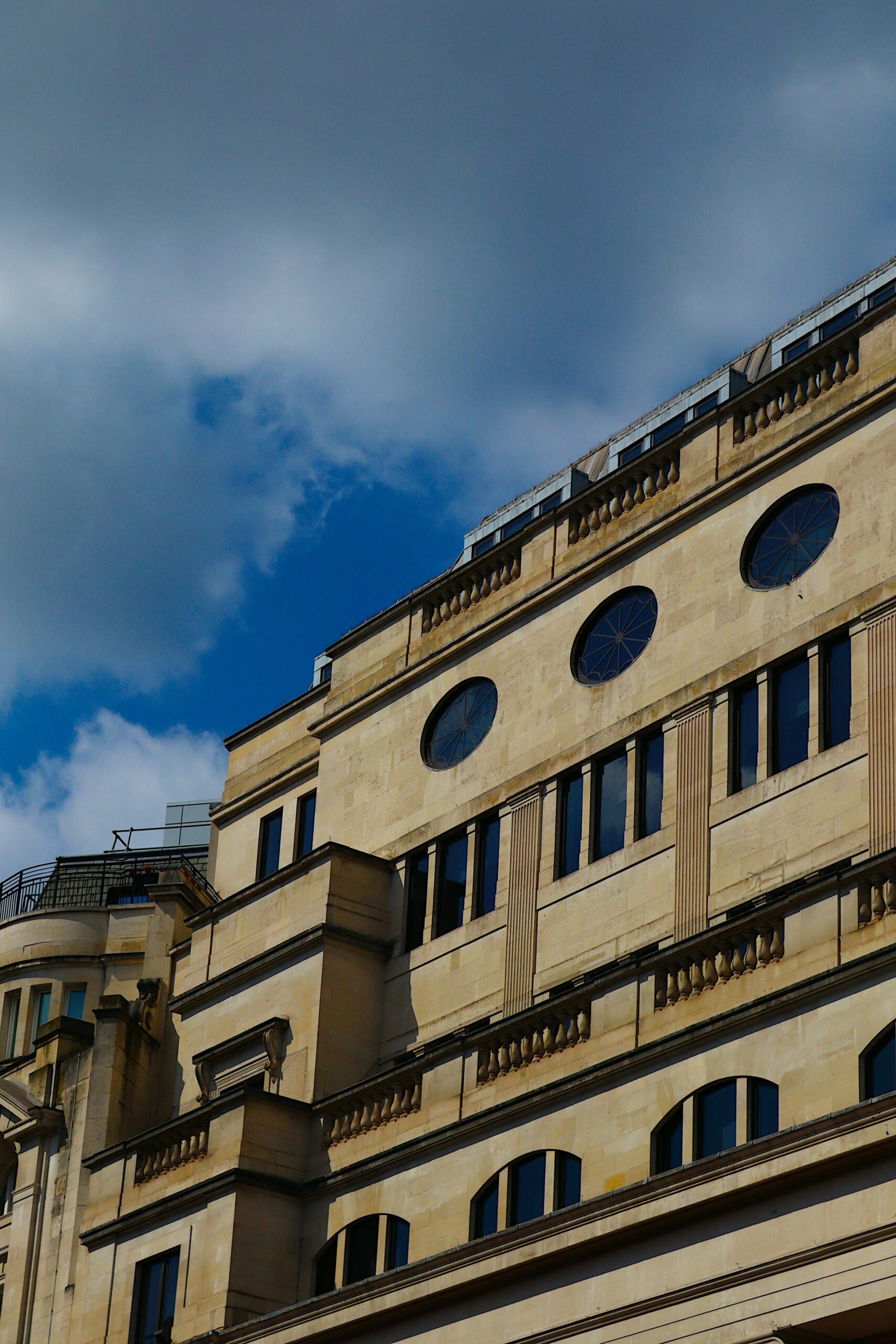 Elegancka fasada budynku w Londynie pod jasnym błękitnym niebem.