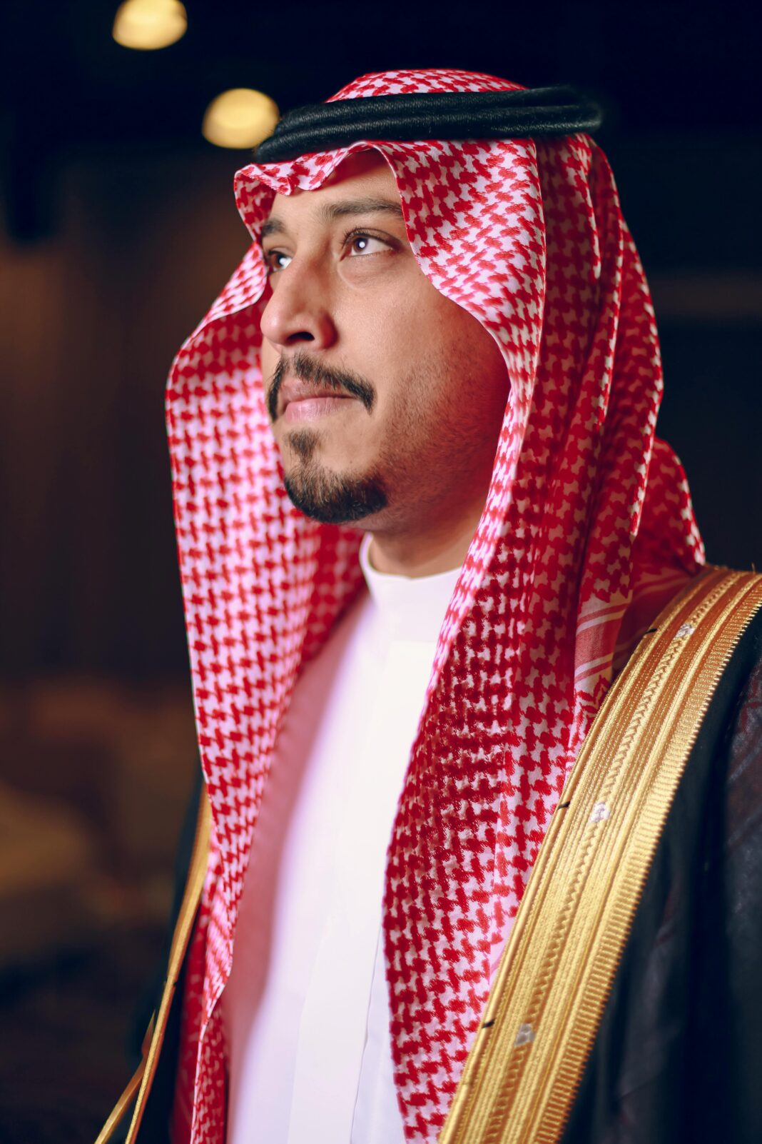 Portret mężczyzny w tradycyjnym stroju bliskowschodnim, w pomieszczeniu.