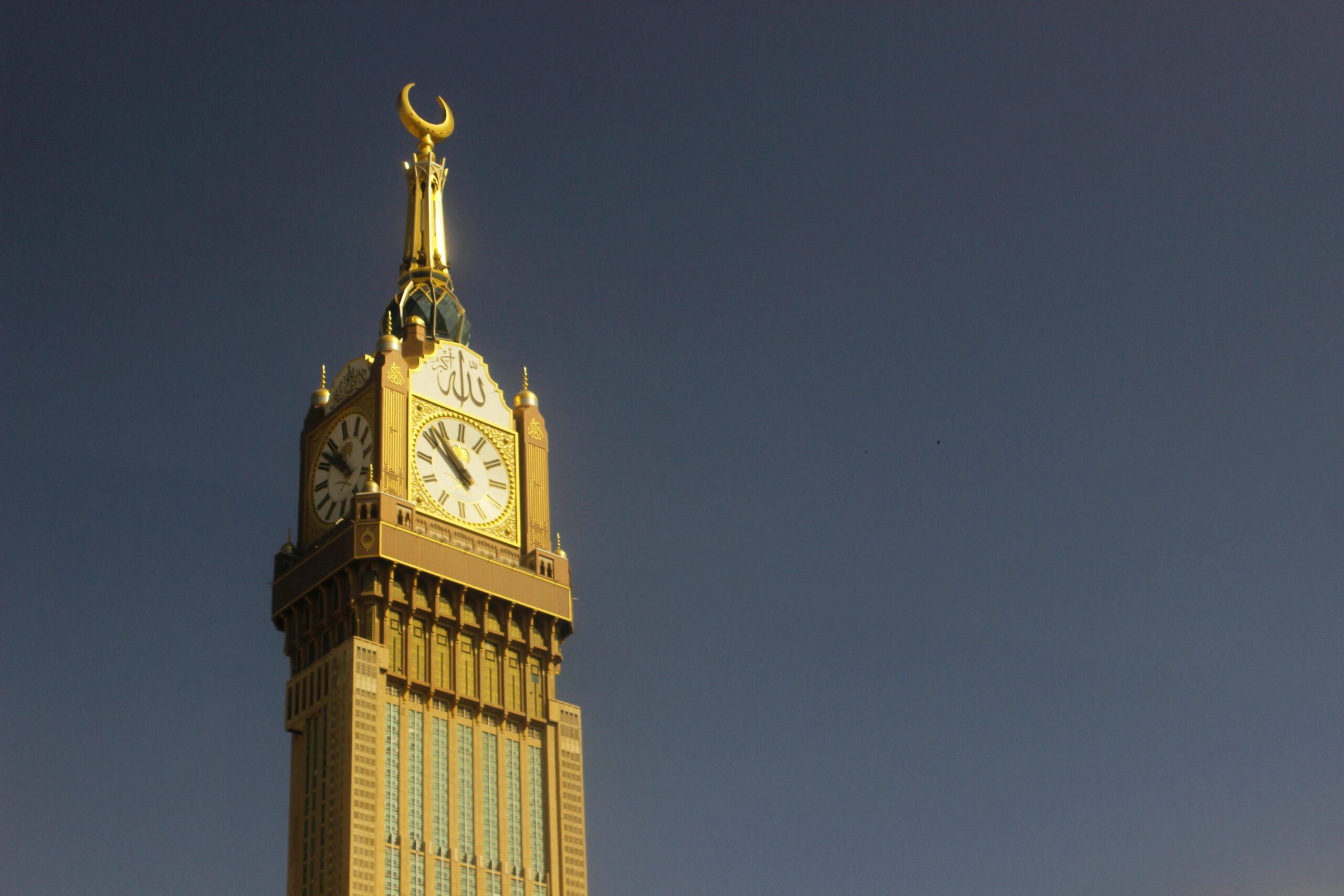 Majestatyczne ujęcie wieży zegarowej Abraj Al Bait w Mekkah na tle czystego nieba.