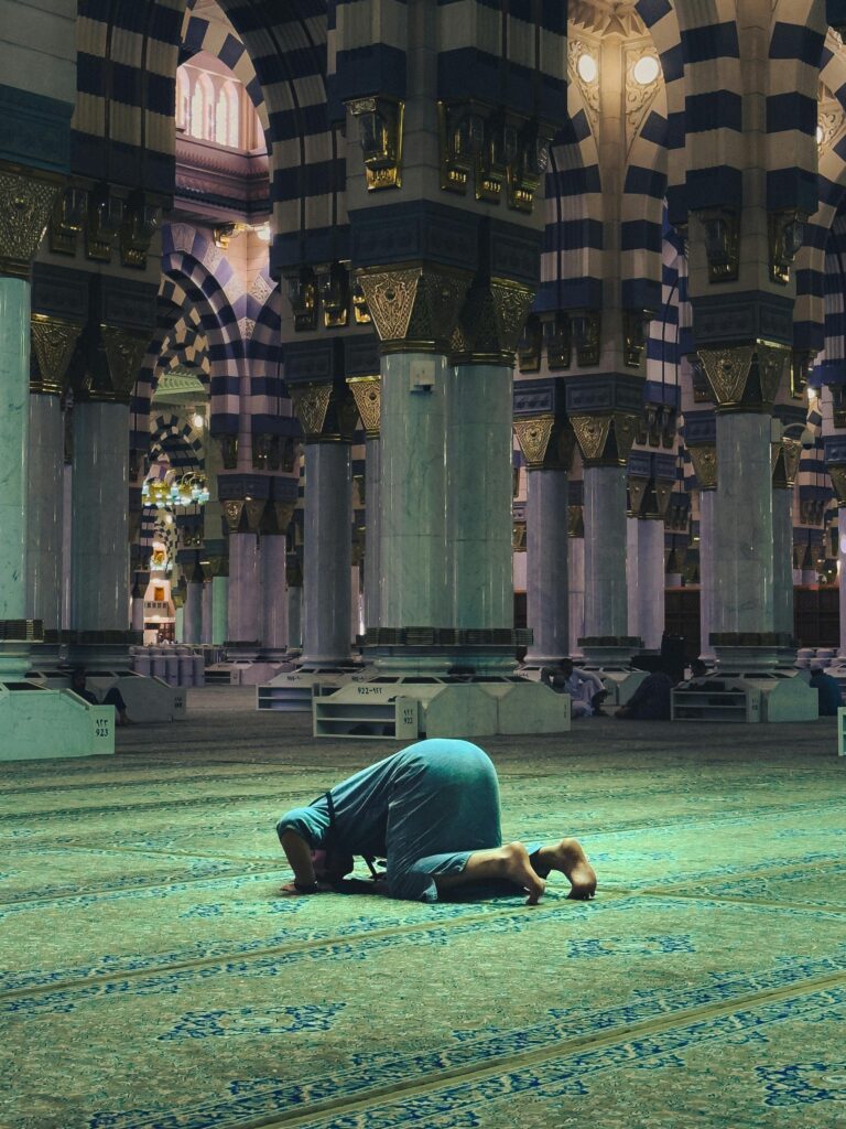 Osoba modląca się w historycznym Al-Masjid an-Nabawi w Medynie, Arabia Saudyjska.