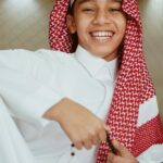 Arabia Saudyjska a prawa kobiet – jak wygląda rzeczywistość? Uśmiechnięty arabski nastolatek ubrany w tradycyjny strój, prezentujący dziedzictwo kulturowe.