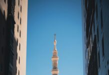 Meczet Proroka i jego kultowe minarety widziane pomiędzy dwoma budynkami w Medynie w Arabii Saudyjskiej.