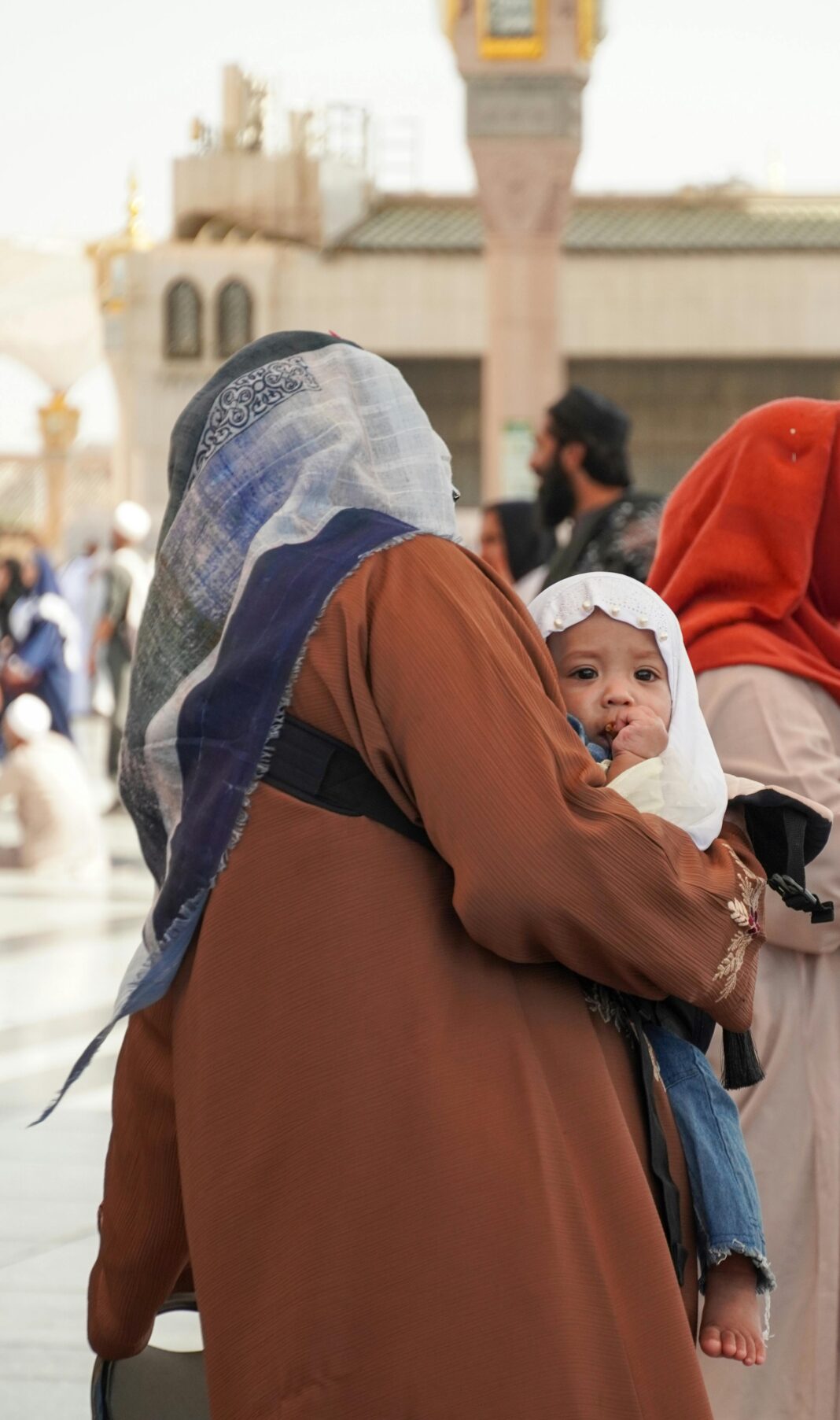Matka z dzieckiem w Al-Masjid an-Nabawi w Medynie w Arabii Saudyjskiej, prezentująca dziedzictwo kulturowe.