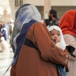Matka z dzieckiem w Al-Masjid an-Nabawi w Medynie w Arabii Saudyjskiej, prezentująca dziedzictwo kulturowe.