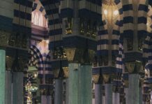 Osoba modląca się w historycznym Al-Masjid an-Nabawi w Medynie, Arabia Saudyjska.