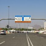 Co warto wiedzieć o kulturze przed podróżą do Arabii Saudyjskiej? Oznakowanie drogowe prowadzące do góry Al Rahmah w Mekce, z pojazdami i ludźmi w słoneczny dzień.