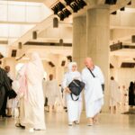 Najczęstsze pytania i odpowiedzi o Arabii Saudyjskiej Pielgrzymi w świętym miejscu w Arabii Saudyjskiej, ubrani w tradycyjne stroje symbolizujące duchowość.