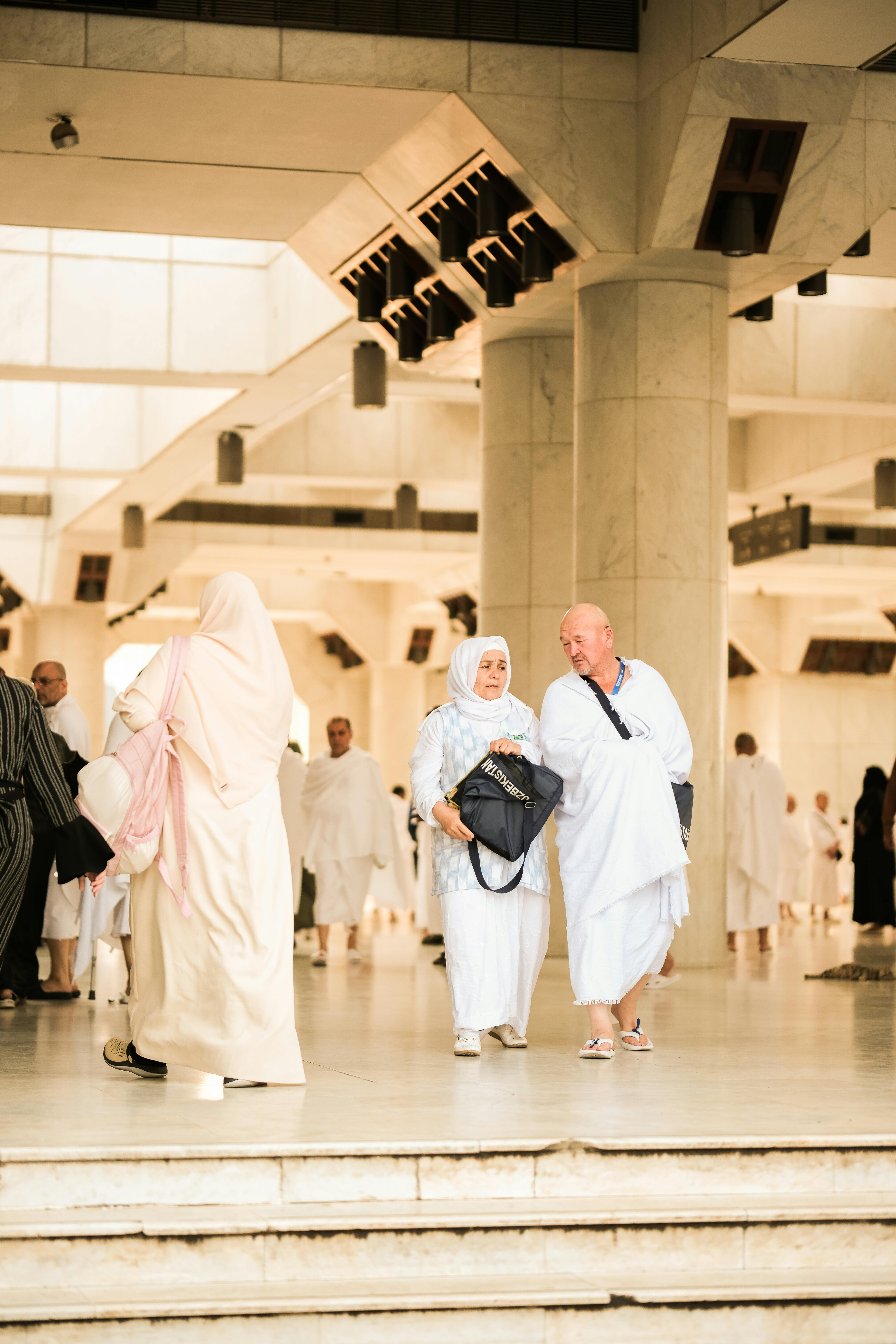arabia-saudyjska Pielgrzymi w świętym miejscu w Arabii Saudyjskiej, ubrani w tradycyjne stroje symbolizujące duchowość.