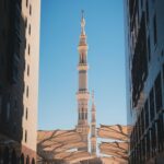 Meczet Proroka i jego kultowe minarety widziane pomiędzy dwoma budynkami w Medynie w Arabii Saudyjskiej.