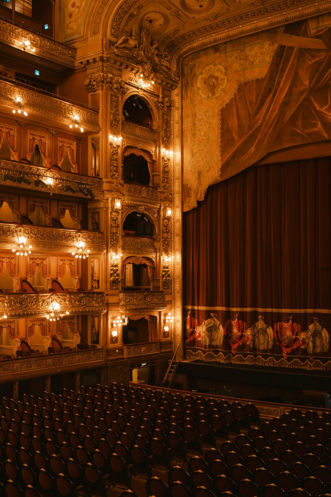 Luksusowe wnętrze Teatro Colón z ozdobnymi balkonami i wielką sceną.