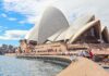 Opera w Sydney z turystami i widokiem na nabrzeże w słoneczny dzień.