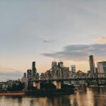 Papugi kakadu i inne egzotyczne ptaki Australii Malowniczy widok na panoramę Brisbane z mostem Story Bridge o zmierzchu nad rzeką Brisbane.