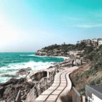 Czy w Australii faktycznie jest więcej niebezpiecznych stworzeń? Malownicza nadmorska ścieżka wzdłuż plaży Bondi, ukazująca tętniące życiem morze i niebo.