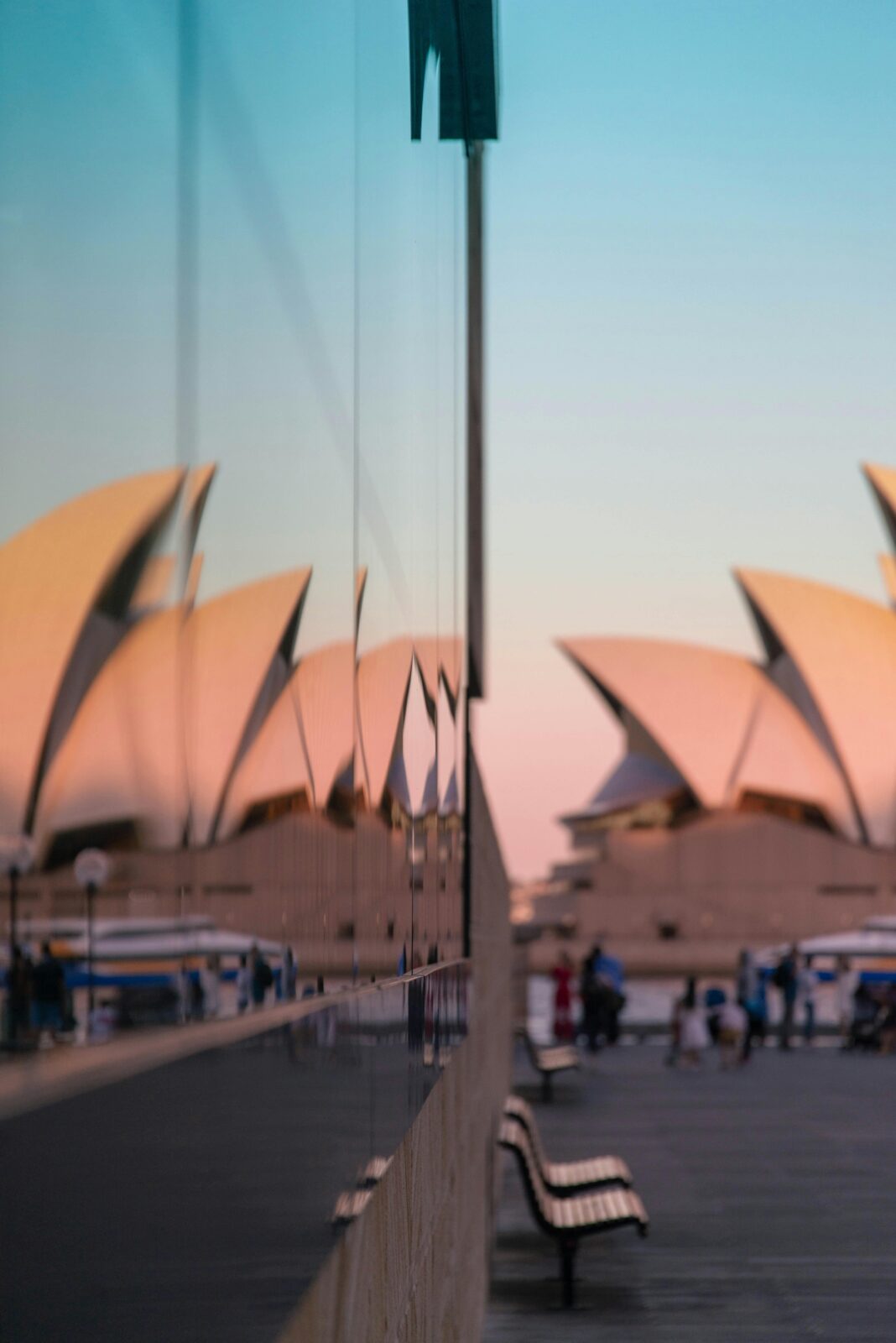 Opera w Sydney odbita w szkle, przedstawiająca kultową architekturę o zmierzchu w Sydney w Australii.