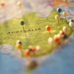 Kiedy najlepiej lecieć do Australii? Przewodnik po porach roku Zbliżenie mapy Australii z kolorowymi pinezkami oznaczającymi różne miasta i miejsca docelowe.