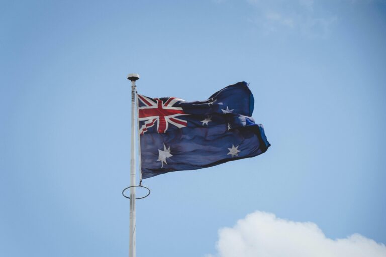 Australijska flaga narodowa macha na maszcie na tle czystego, błękitnego nieba w Perth.