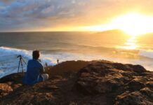 Przyszłość energetyki w Australii – OZE kontra węgiel Fotograf uchwycił oszałamiający zachód słońca na australijskim wybrzeżu ze statywem, a poniżej fale rozbijające się.