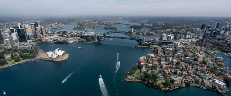Oszałamiający widok z lotu ptaka przedstawiający operę w Sydney i most Harbour Bridge w świetle dziennym.