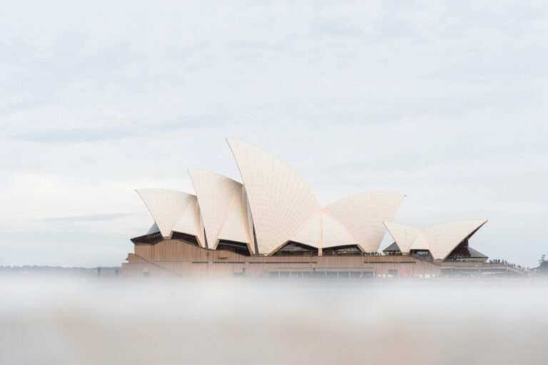 Mglisty widok na kultową Operę w Sydney w Australii, ukazujący jej charakterystyczną architekturę przypominającą żagiel.