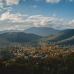 Emigracja do Australii – co trzeba wiedzieć? Odkryj zapierającą dech w piersiach scenerię Bright w stanie Wiktoria z bujną zielenią i majestatycznymi górami pod żywym niebem.