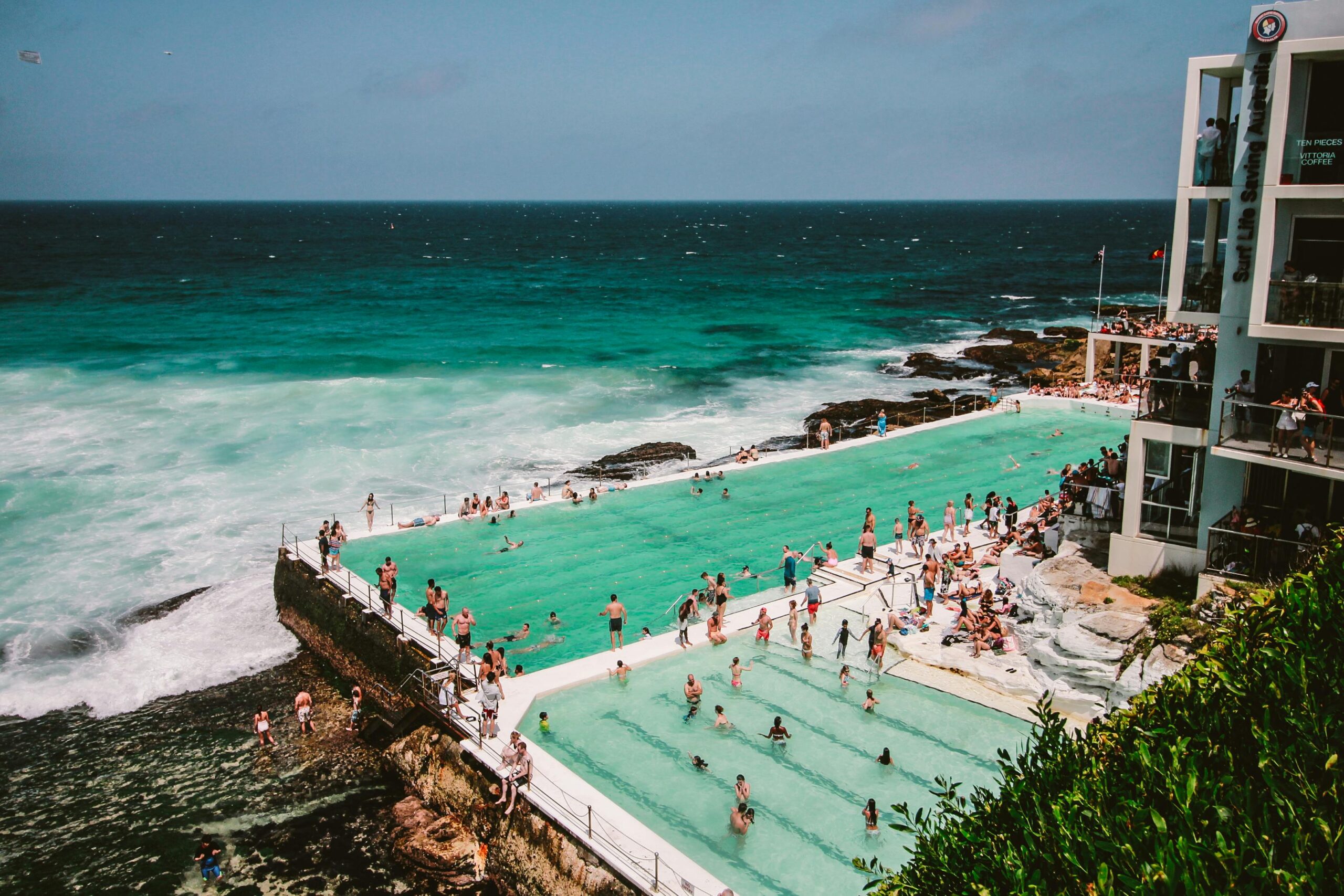 Tętniąca życiem scena ludzi korzystających z basenu Bondi Icebergs nad oceanem w Sydney w Australii.