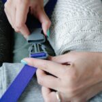 Ręce zapinające klamrę szybkiego zwalniania w bagażu podróżnym.