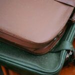 Zbliżenie na stos starych skórzanych walizek w różnych kolorach, prezentujących ponadczasowy styl podróżowania.