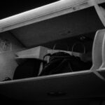 Zbliżenie na schowek nad głową samolotu z bagażem w środku.