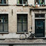 Zabytkowa ceglana fasada z rowerem w Gandawie w Belgii, przedstawiająca klasyczną architekturę europejską.