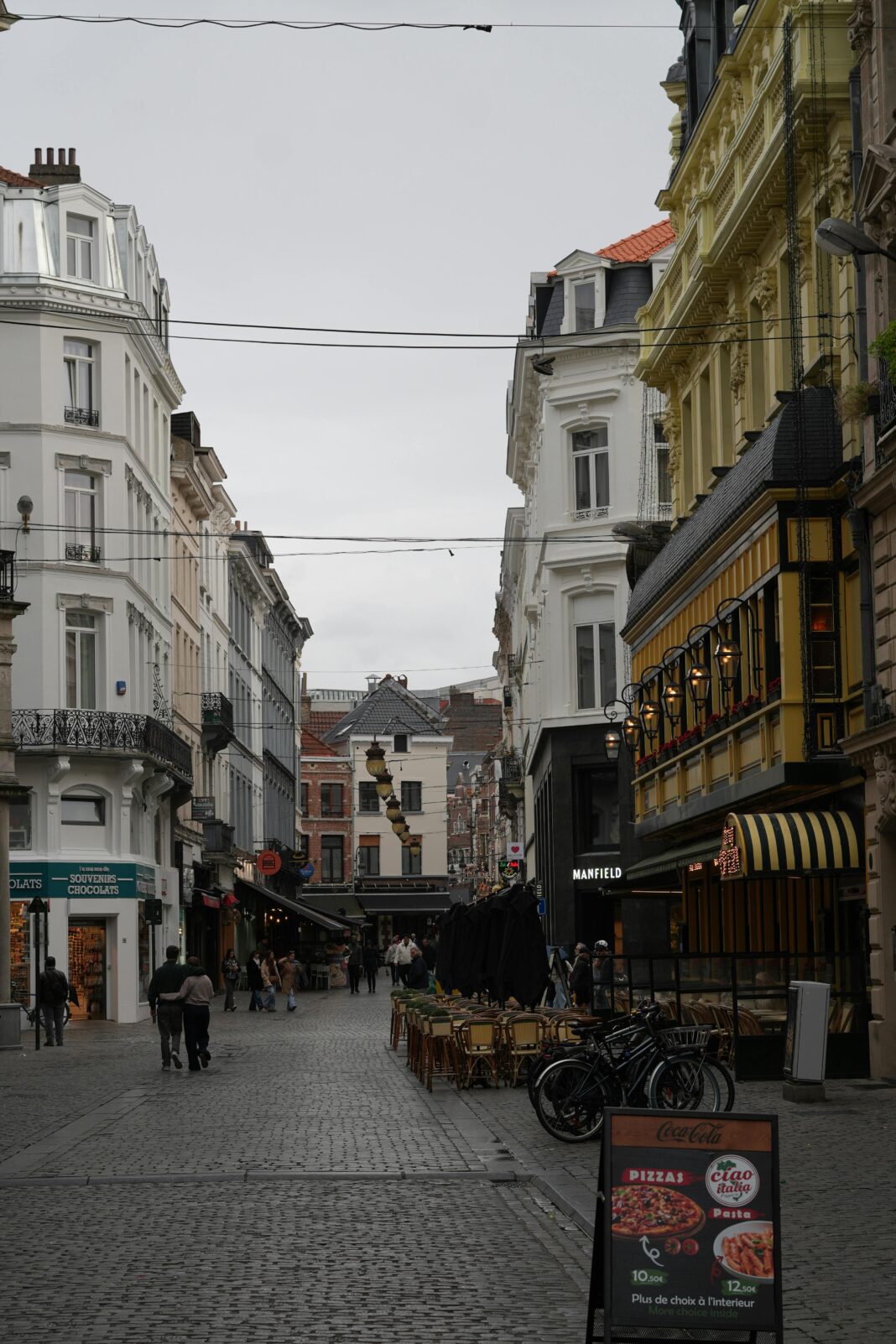 belgia Urocza brukowana ulica w Brukseli z kawiarniami i klasyczną architekturą.