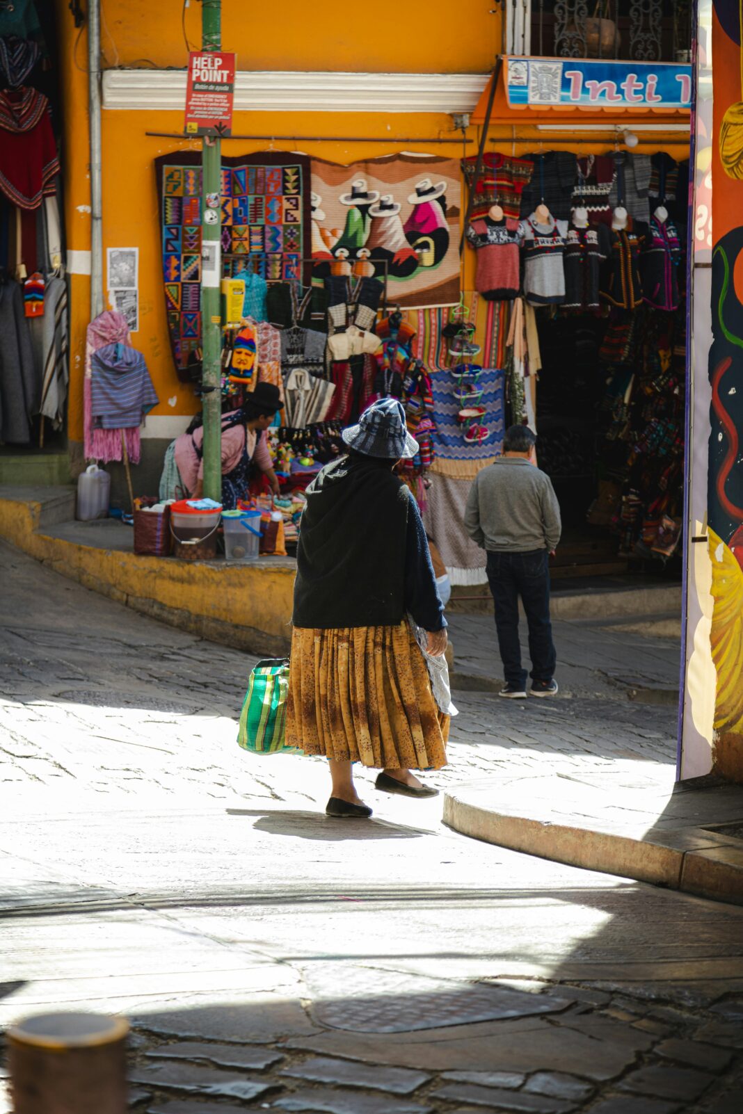 Tętniąca życiem scena w La Paz z ludźmi i tradycyjnymi sklepami z pamiątkami na brukowanych uliczkach.