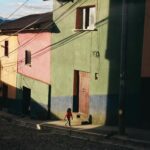 Tajemnice boliwijskiego wina – Wizyta w winnicach Tarija Dziecko spaceruje po kolorowych domach w Coroico w Boliwii, w świetle słonecznym.