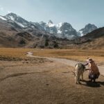 Kobieta z mułem na drodze w malowniczych górach Condoriri w Boliwii.