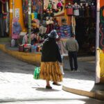 Tętniąca życiem scena w La Paz z ludźmi i tradycyjnymi sklepami z pamiątkami na brukowanych uliczkach.