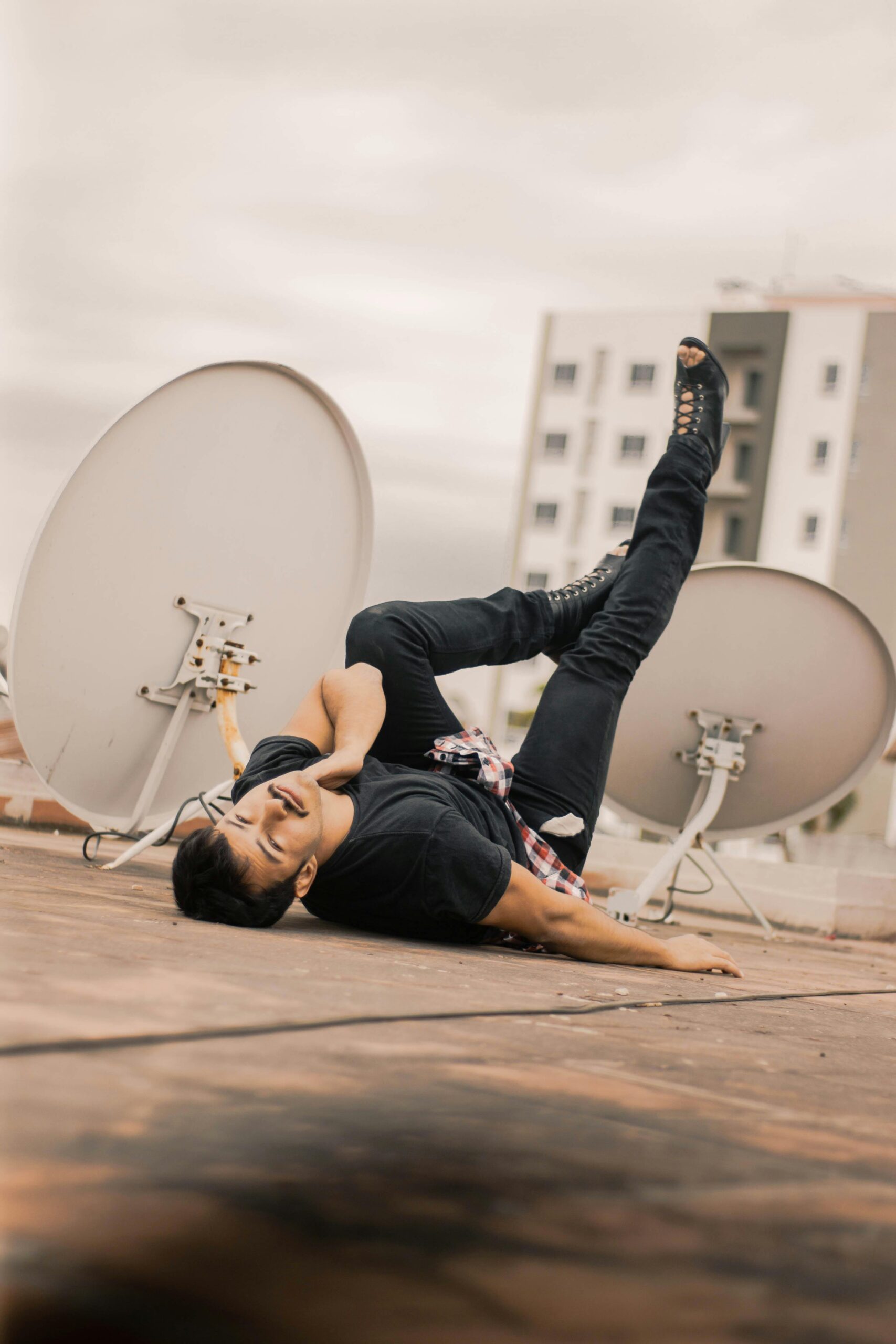 Energiczny tancerz breakdance występujący na dachu w Santa Cruz pod zachmurzonym niebem.