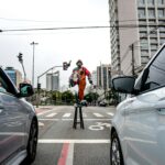 Klaun występujący na ruchliwej ulicy w São Paulo, uwieczniający miejskie życie i ruch uliczny.