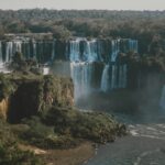 Odkryj zapierające dech w piersiach wodospady Iguazu opadające kaskadą pośród zielonych krajobrazów Brazylii.