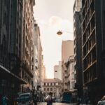 Cukrowa Głowa: Niezapomniany widok na Rio de Janeiro Osoba przechodzi przez ruchliwą ulicę w centrum Sao Paulo, pośród architektury miejskiej o zachodzie słońca.