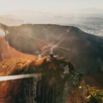 Oszałamiający widok z lotu ptaka Chrystusa Odkupiciela w Rio de Janeiro o wschodzie słońca, ukazujący żywe promienie słoneczne i zapierający dech w piersiach krajobraz.