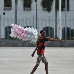 Sprzedawca uliczny w Rio de Janeiro sprzedający kolorową watę cukrową, spacerujący na świeżym powietrzu.