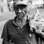 Brazylijskie święta i festiwale, które warto zobaczyć Portret starszego mężczyzny w czapce trzymającego worek, uchwycony w czerni i bieli.