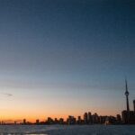 Urzekający widok o zmierzchu na panoramę Toronto i wieżę CN odbijającą się nad jeziorem Ontario